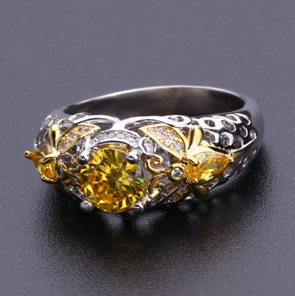 Alloy geometric zircon ring with intricate detailing and yellow stone on black background.