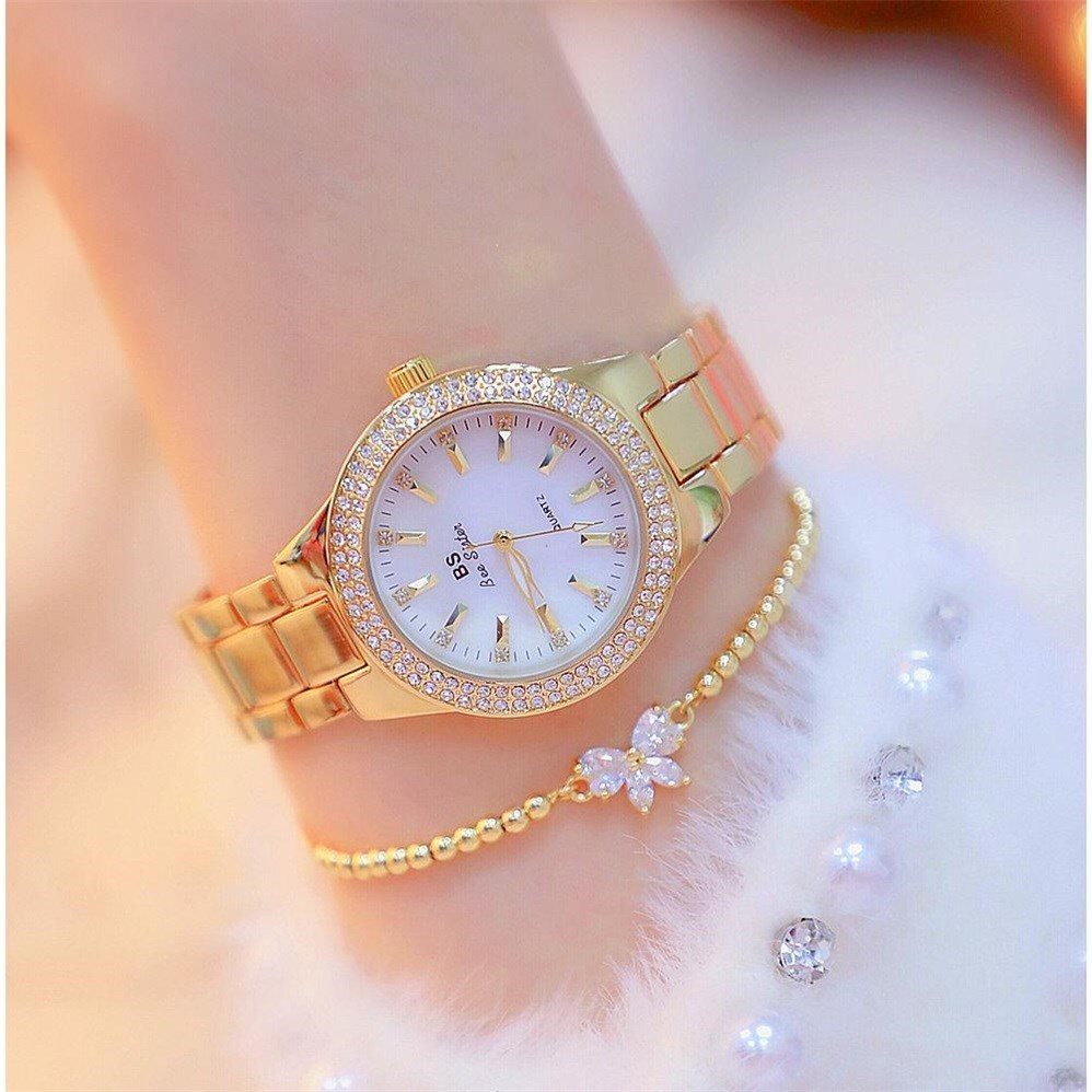 Mechanical watch with gold bracelet and bow embellishment on a woman&