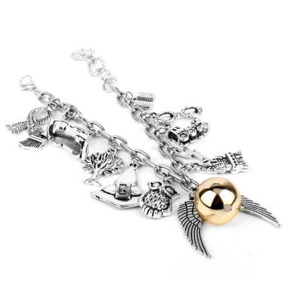 Angel wings bracelet in gold and silver alloy with various charms.