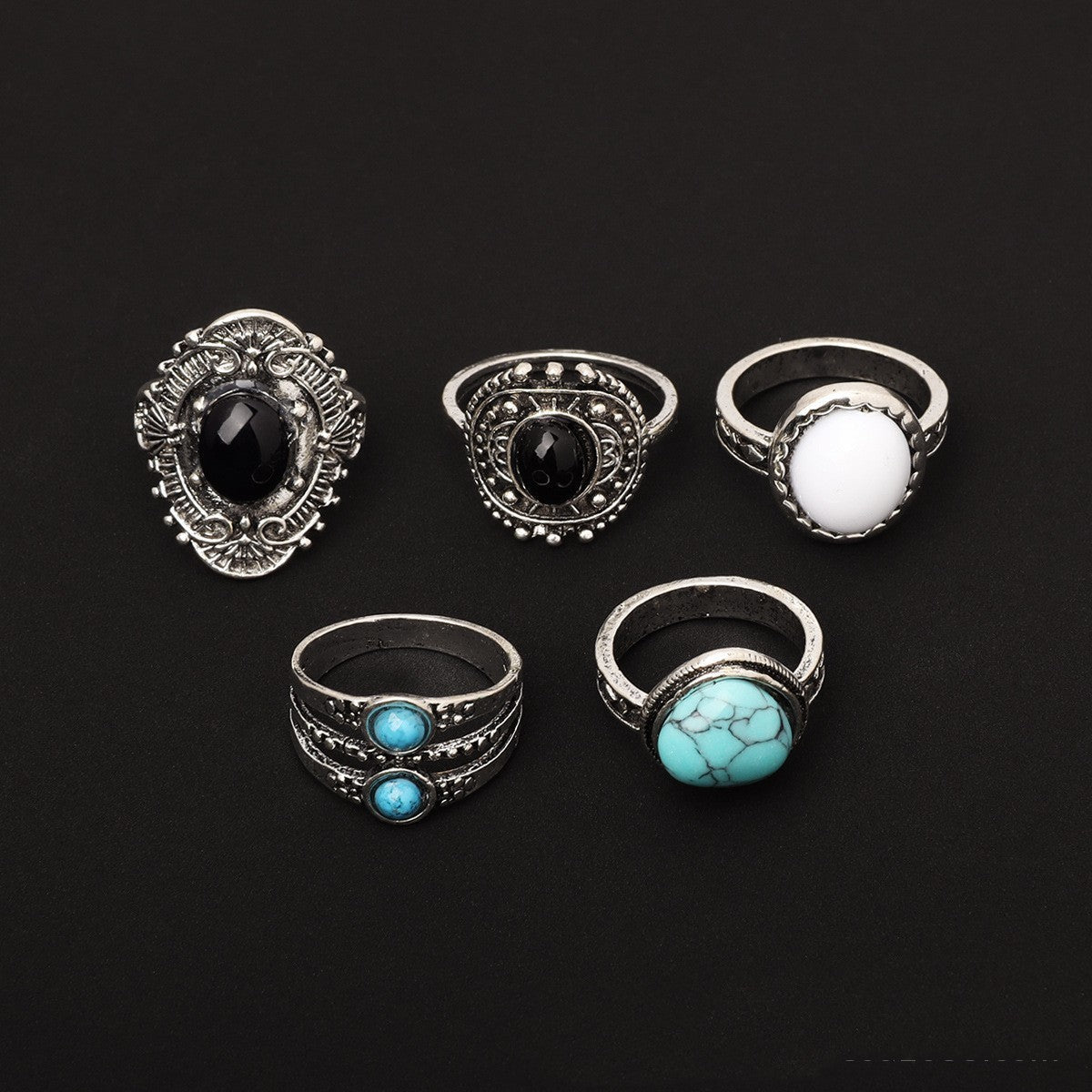 5-piece set of geometric alloy joint and statement rings on black background.