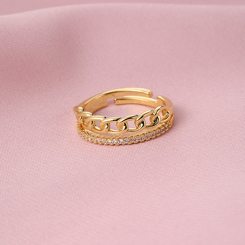 Versatile gold fashion ring on pink fabric background.