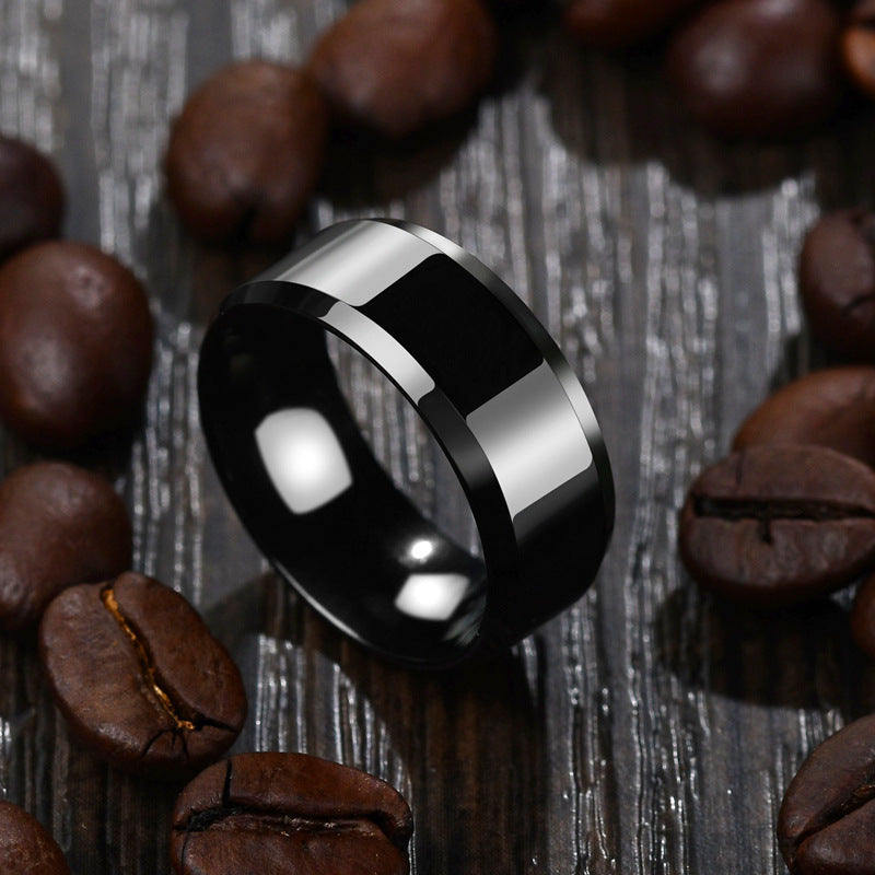 Stainless steel black geometric ring for women and men on textured surface.