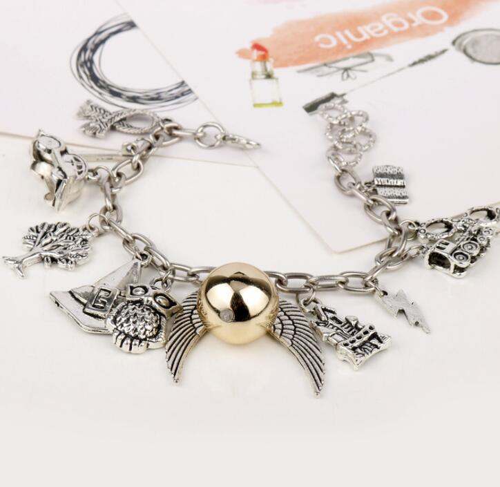 Angel wings bracelet in gold and silver alloy, adorned with various charms, 25CM inner length.