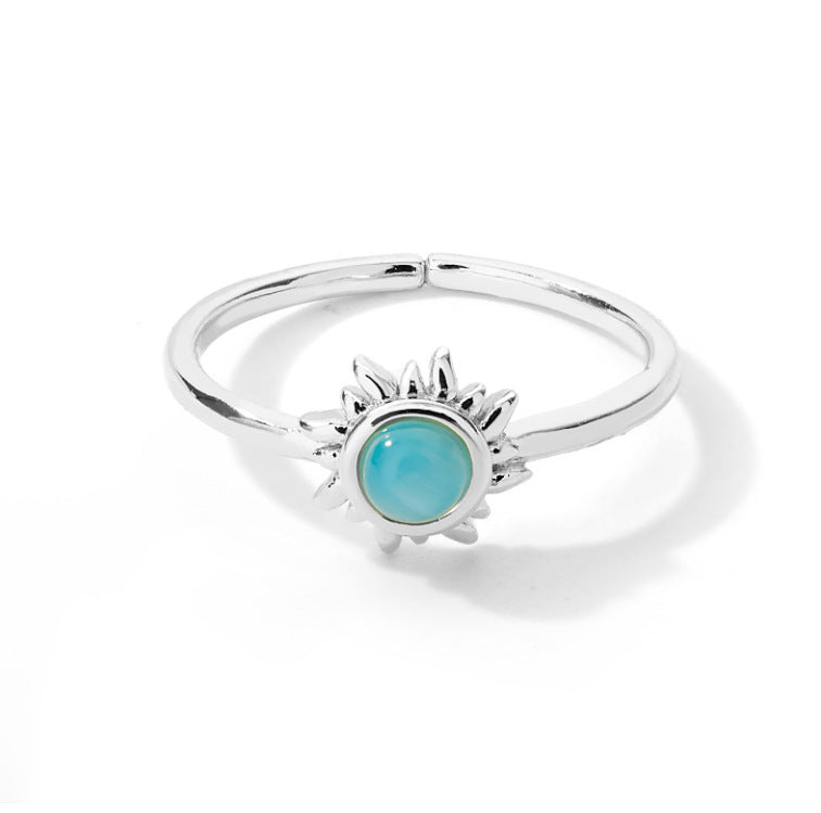 Stainless steel ring with blue opal center and sunburst design.