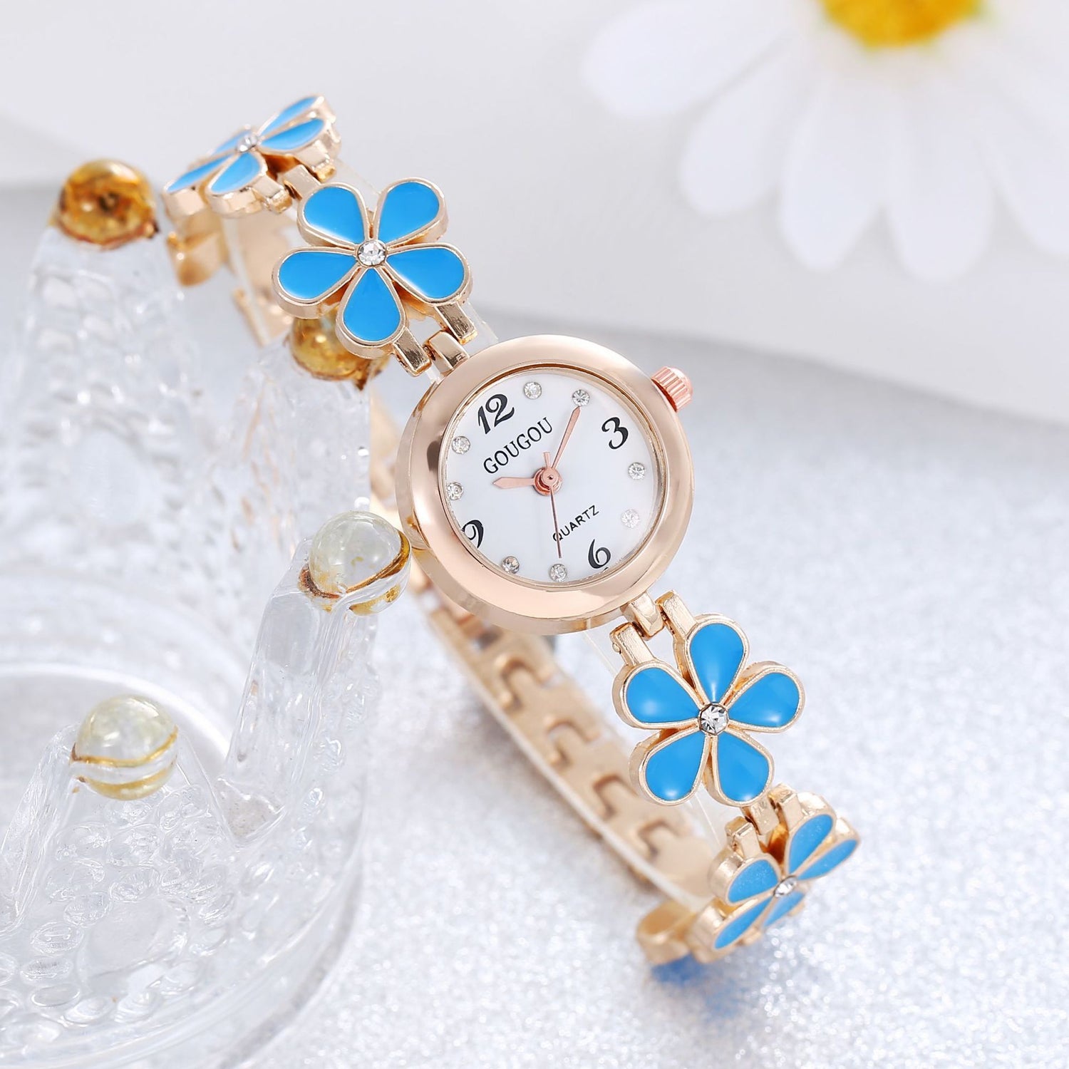 Ladies petal patterned quartz watch bracelet set with blue flower accents.