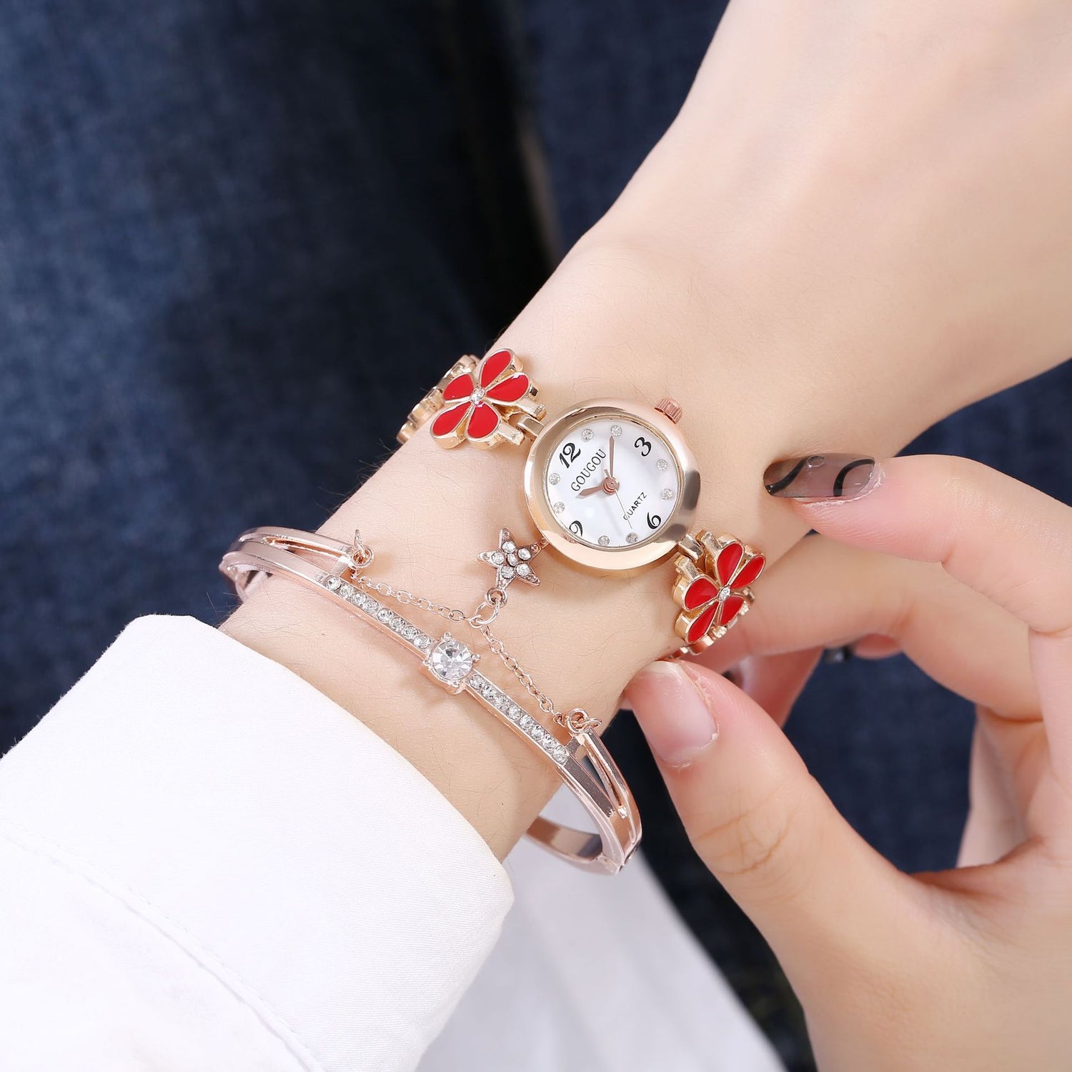 Ladies petal patterned quartz watch and bracelet set in red design worn on wrist.