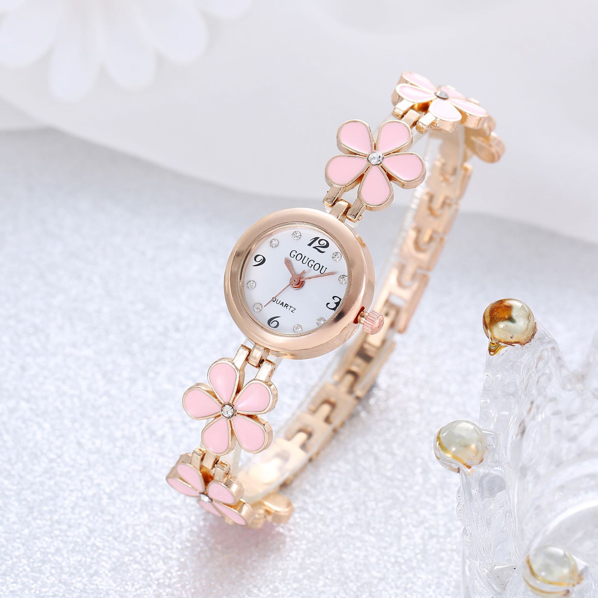 Ladies petal patterned quartz watch bracelet set with pink floral design and circular alloy dial.